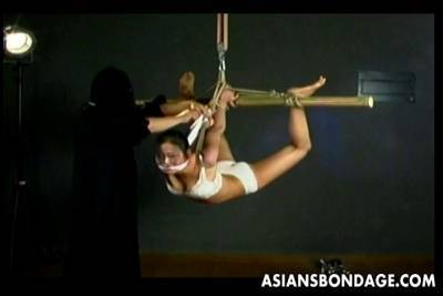 Submissive Asian brunette bitch gets gagged and suspended with rope - bdsm.one