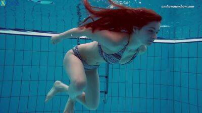 Busty and beautiful fresh redhead babe in the pool undresses underwater - sunporno.com