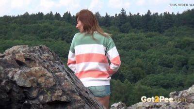 Pretty girl takes a piss while out walking in the country - sexu.com
